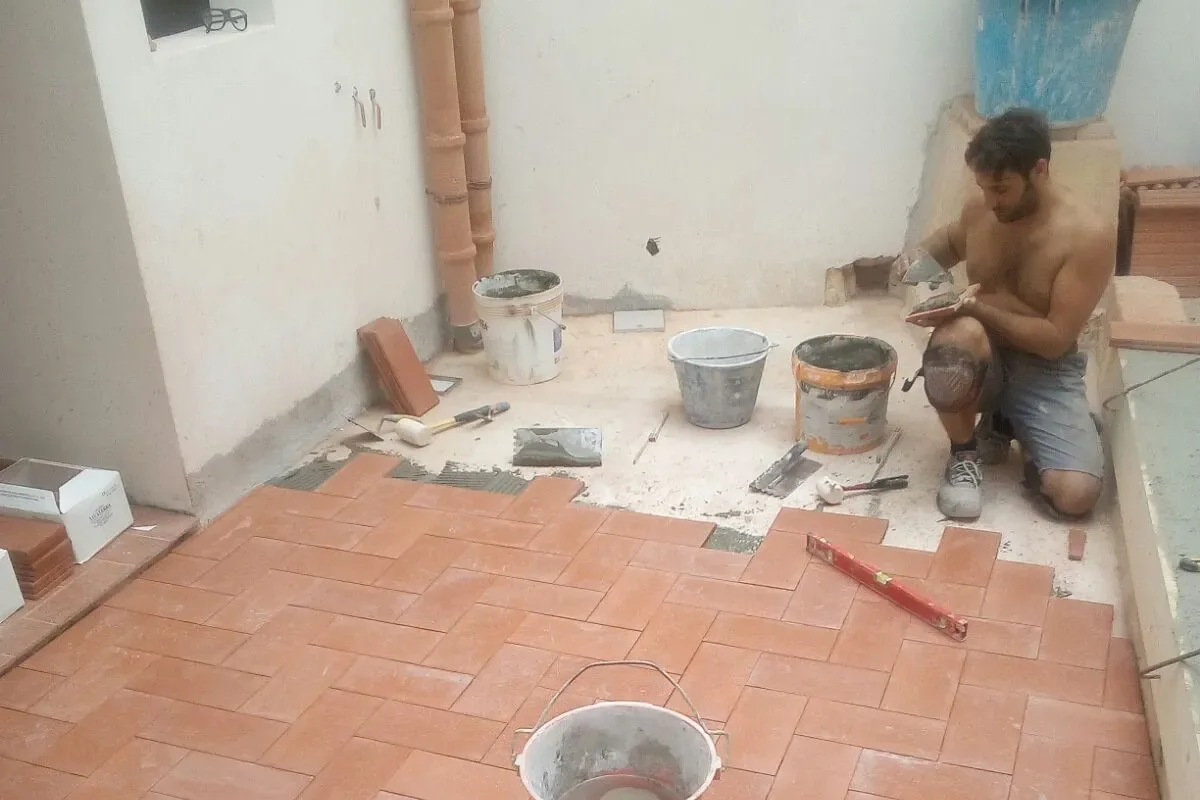 Alfonso, muratore di Edilizia Palermo, al lavoro sulla posa di un pavimento in cotto